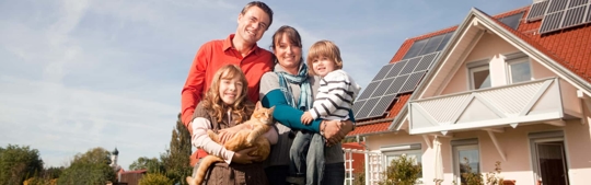 A family in front of their solar powered home