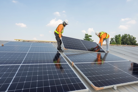 solar panels being installed atop a commercial building
